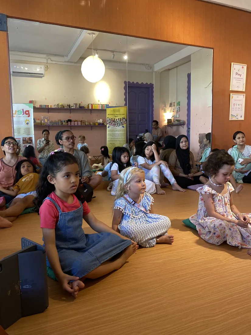Children gathered on the floor listening to the story