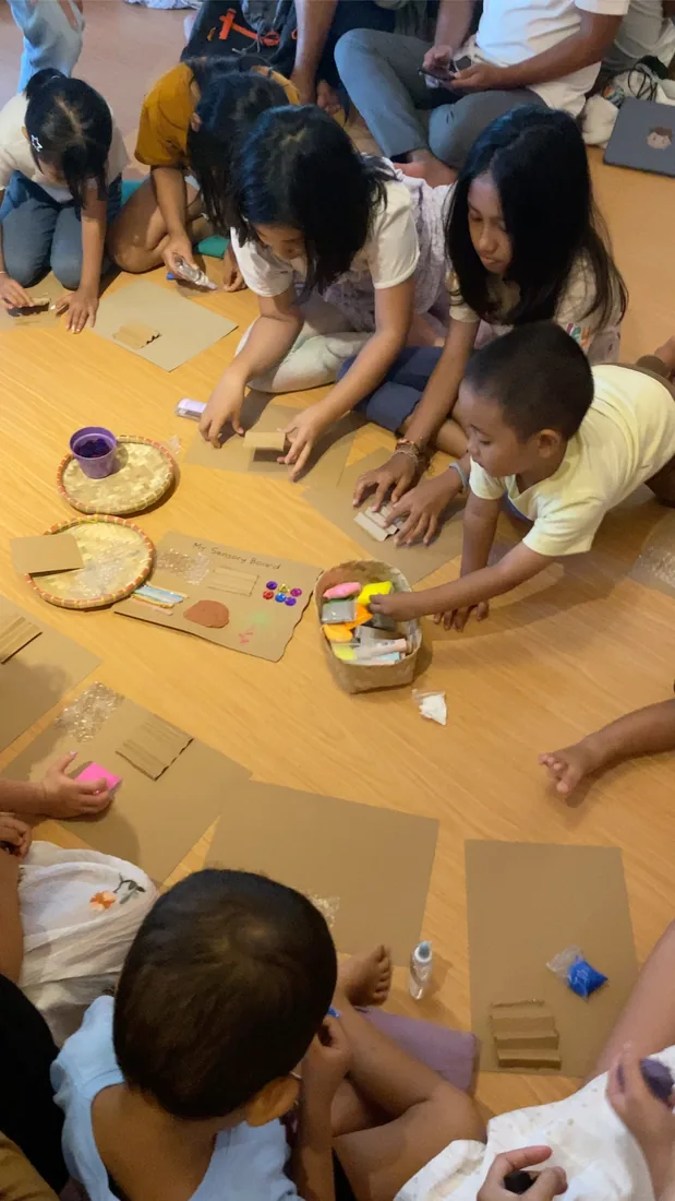 Children making sensory boards together